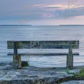 Tranquil Waterfront Bench at Sunset: Serene Nature Escape