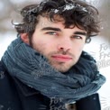 Winter Portrait of a Young Man with Scarf in Snowy Landscape