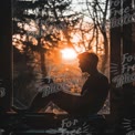 Cozy Reading at Sunset: Silhouette of a Man Enjoying a Book by the Window