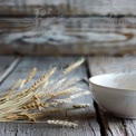 Rustic Still Life: Natural Wheat Stalks and Minimalist Ceramic Bowl on Weathered Wood