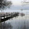 Serene Foggy Lake with Wooden Pier and Reflections