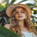 Summer Vibes: Young Woman in Straw Hat Surrounded by Tropical Foliage