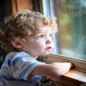 Curious Child Gazing Out the Window: Innocence and Wonder