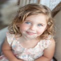 Charming Portrait of a Smiling Young Girl with Blue Eyes in Soft Natural Light