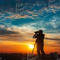 Silhouette of Photographer Capturing Sunset Over City Skyline