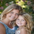 Joyful Mother and Daughter Embracing in Nature with Blossoming Flowers