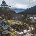 Serene Mountain Landscape with Mossy Rocks and Lush Forests