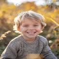 Joyful Child in Autumn Field: Smiling Boy with Golden Light