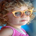 Charming Child with Curly Hair and Stylish Sunglasses: Summer Fun and Playfulness