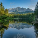 Tranquil Mountain Reflection in Serene Lake Surrounded by Lush Forest