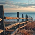 Tranquil Lakeside Fence at Sunset: Serene Nature Landscape