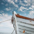 Rustic Boat Bow Against a Blue Sky with Clouds