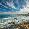 Serene Coastal Landscape with Dramatic Sky and Rocky Shoreline