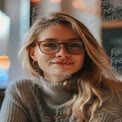 Charming Young Woman with Glasses in Cozy Cafe Setting