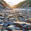 Serene Sunset Over Pebbled Beach: Nature's Tranquility and Coastal Beauty