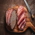 Artisan Sliced Ham on Wooden Cutting Board with Knife - Gourmet Food Presentation