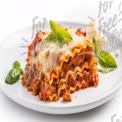 Delicious Homemade Lasagna with Fresh Basil and Cheese on a White Plate