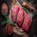 Fresh Raw Beef Cuts with Spices and Herbs on Rustic Wooden Background