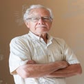 Confident Senior Man with Arms Crossed in Neutral Background