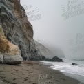 Serene Coastal Landscape: Misty Beach with Dramatic Cliffs and Gentle Waves