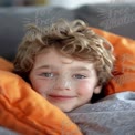 Cozy Child Portrait: Joyful Boy Relaxing with Soft Blankets