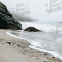 Serene Coastal Landscape: Misty Beach with Rocky Shoreline and Gentle Waves