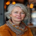 Confident Mature Woman with Short Gray Hair and Colorful Scarf in Cozy Cafe Setting