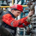 Industrial Worker in Safety Gear Operating Machinery in Manufacturing Plant