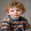 Charming Young Boy with Curly Hair in Striped Shirt - Portrait of Childhood Innocence