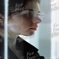 Contemplative Young Woman with Glasses in Modern Urban Setting