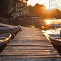 Tranquil Sunset Over Serene Lake with Boats and Dock