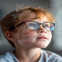 Curious Boy with Glasses Gazing Thoughtfully Indoors