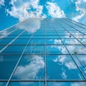 Modern Skyscraper Reflection: Blue Sky and Clouds in Glass Facade