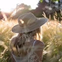 Serene Summer Moments: Woman in Sunlit Field with Straw Hat