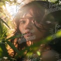 Enchanting Portrait of a Woman Surrounded by Nature's Light and Greenery