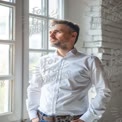 Contemplative Businessman Looking Out Window in Modern Office