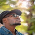 Contemplative Man in Sunglasses Against a Blurred Nature Background