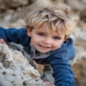 Adventurous Child Climbing Rocks: Joyful Exploration and Outdoor Play