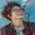 Joyful Young Woman with Stylish Glasses and Casual Fashion Against Vibrant Background