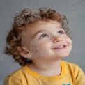 Joyful Child with Curly Hair Looking Upwards - Innocence and Wonder