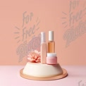 Elegant Skincare Display with Floral Accents on Soft Pink Background