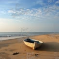 Ruhige Strandlandschaft mit verlassenem Boot bei Sonnenaufgang