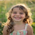 Joyful Child in Nature: Smiling Girl in Sunlit Field