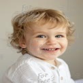 Joyful Toddler Portrait with Bright Smile and Curly Hair