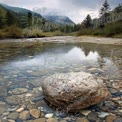 Tranquil Mountain Stream with Reflections and Scenic Landscape