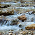 Serene Mountain Stream Flowing Over Rocks - Nature's Tranquility