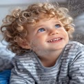 Joyful Child with Curly Hair and Bright Blue Eyes, Capturing Innocence and Happiness