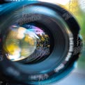 Close-Up of Camera Lens Reflecting Nature: Photography and Creativity Concept