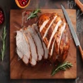 Deliciously Roasted Turkey Breast with Fresh Herbs and Berries on Wooden Cutting Board