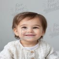 Adorable Smiling Toddler with Natural Expression on Soft Gray Background